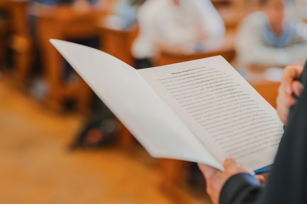 Zdjęcie przedstawia dłoń, w której trzymana jest otwarta książka