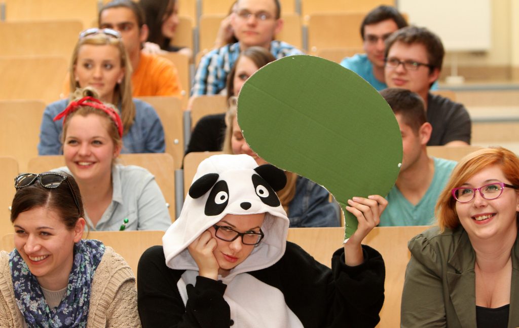 studenci w sali w tle studentki w przebraniu zwirzaka