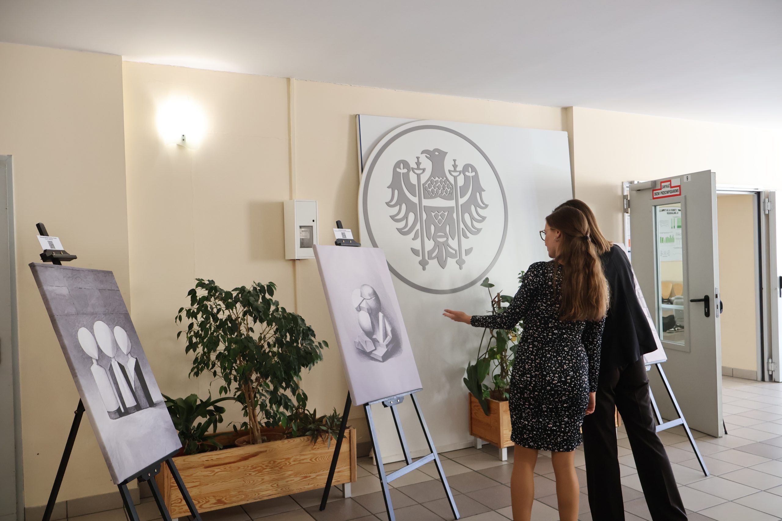 zdjęcia osób ogladających wystawę w holu IPoL